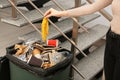 Young woman throwing banana peel in trash bin indoors, closeup. Royalty Free Stock Photo