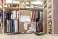 Young woman throwing clothes in walk in closet. Mess in wardrobe and dressing room Royalty Free Stock Photo