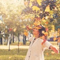 Young woman throwing fall leaves in autumn park Royalty Free Stock Photo