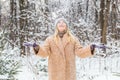 Young woman throwing snow in the air at sunny winter day, she is happy and fun Royalty Free Stock Photo