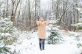 Young woman throwing snow in the air at sunny winter day, she is happy and fun. Royalty Free Stock Photo