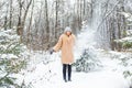 Young woman throwing snow in the air at sunny winter day, she is happy and fun. Royalty Free Stock Photo