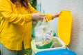 young woman throws garbage bag in the trash sorting waste, female in casual wear, eco-friendly person save planet Royalty Free Stock Photo