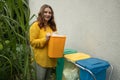 young woman throws garbage bag in the trash sorting waste, female in casual wear, eco-friendly person save planet Royalty Free Stock Photo