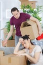 Young woman tired while unpacking boxes disapproving boyfriend