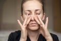 A young woman touches her nose with her fingers because of the loss of her sense of smell, does not feel the smell