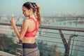 Young woman touching hair while running on the bridge, back view