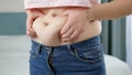 Young woman touching her big belly and holding fat folds. Concept of excessive weight, obese female, dieting and Royalty Free Stock Photo