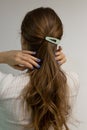 young woman touching her blond natural hair.