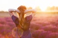 Young woman touching her long sombre hair looking at lavender field at sunset Royalty Free Stock Photo