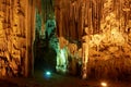 Young woman touching stalactites. Melidoni Cave