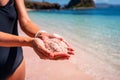 Young woman tourism holding sand at the tropical pink sandy beach at Komodo islands Royalty Free Stock Photo