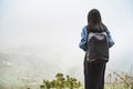 Young woman tourist with backpack relaxing on top of a mountain and enjoying the view of valley Royalty Free Stock Photo