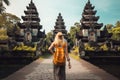 Young woman tourist with backpack standing at Pura Besakih temple in Bali, Indonesia, Tourist woman with backpack at vacation