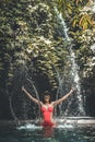 Happy Young woman tourist with straw hat in the deep jungle with waterfall. Real adventure concept. Bali island. Royalty Free Stock Photo