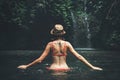 Young woman tourist with straw hat in the deep jungle with waterfall. Real adventure concept. Bali island. Royalty Free Stock Photo