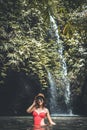 Young woman tourist with straw hat in the deep jungle with waterfall. Real adventure concept. Bali island. Royalty Free Stock Photo