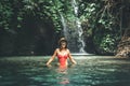 Young woman tourist with straw hat in the deep jungle with waterfall. Real adventure concept. Bali island. Royalty Free Stock Photo