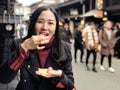 Young woman tourist enjoy eating Japanese street food Hida Beef Sushi and cracker at Takayama, Japan Royalty Free Stock Photo