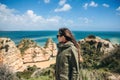 A young woman tourist enjoys beautiful views of the Atlantic Ocean and the landscape. Royalty Free Stock Photo