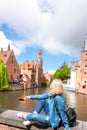 A young woman with the flag of Belgium in her hands is enjoying the view of the canals in the historical center of Royalty Free Stock Photo