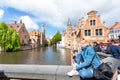 A young woman with the flag of Belgium in her hands is enjoying the view of the canals in the historical center of Royalty Free Stock Photo