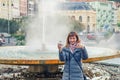 Young woman tourist with grey jacket posing, thumbs up and take therapeutic mineral water