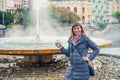 Young woman tourist with grey jacket smile and hold therapeutic mineral water