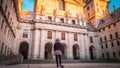 A young woman tourist with her back in front of the Basilica at El Escorial in Spain