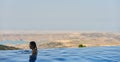 Young Woman tourist in infinity pool Royalty Free Stock Photo