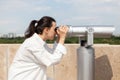 Young woman tourist looking through binoculars telescope Royalty Free Stock Photo