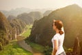 Woman tourist looking far away and enjoying valley and hills view from top of a mountain Royalty Free Stock Photo