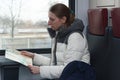 Young woman tourist looking at the map in the train
