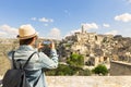 Young woman tourist makes a panorama photo of the ancient city of Matera on a sunny day, Italy Royalty Free Stock Photo