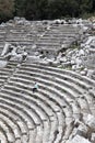Young woman tourist sits alone in the ancient amphitheatre of Termessos in Turkey