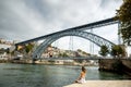 Young woman tourist sitting with great cityscape view on Porto c