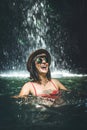 Young woman tourist smiling in the deep jungle with waterfall. Real adventure concept. Bali island. Royalty Free Stock Photo