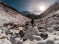 Young woman tourist standing at rock and wathing sun in winter at Chalaadi Glacier