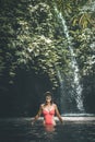 Young woman tourist with straw hat in the deep jungle with waterfall. Real adventure concept. Bali island. Royalty Free Stock Photo