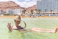 Young woman tourist swimming floating salty water, Dead sea. Royalty Free Stock Photo