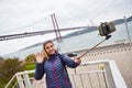 Young woman tourist take selfies on the background of famous iron 25th of April bridge in Lisbon city, Portugal Royalty Free Stock Photo