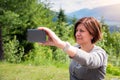 Young Woman Tourist Taking a Selfie in a Park on a Sunny Summer Day Royalty Free Stock Photo