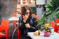 Young woman tourist tasting Baba napoletano al rum in the cafe