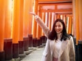 Young woman tourist travel Kyoto, Japan at Fushimi Inari Shrine gate at sunrise