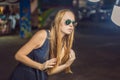 Young woman tourist trying on glasses on Walking street Asian market