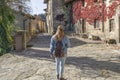 Young woman tourist walking with jeans and small backpack in old medieval village.Traveling concept in Rupit Barcelona Spain