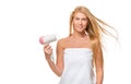 Young woman in towel dries hair a hairdryer