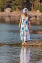 Young woman with a towel on her head at the sea. The lady walks on the water. The concept of summer outdoor recreation, relaxation