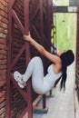 Young woman traceur climbing an obstacle while participating in parkour. Royalty Free Stock Photo