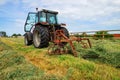 young woman in tractor turning hay in pasture Royalty Free Stock Photo